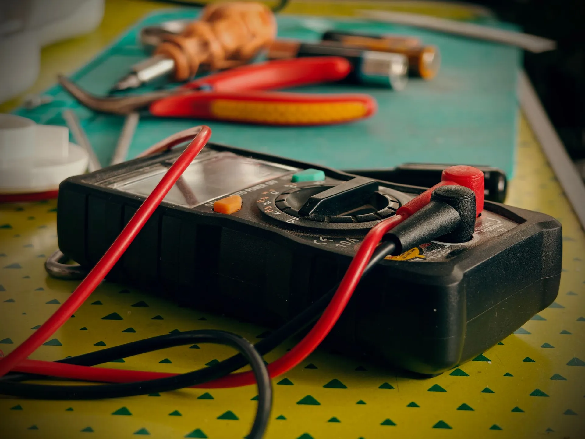 Electrical test meter and hand tools on a workbench