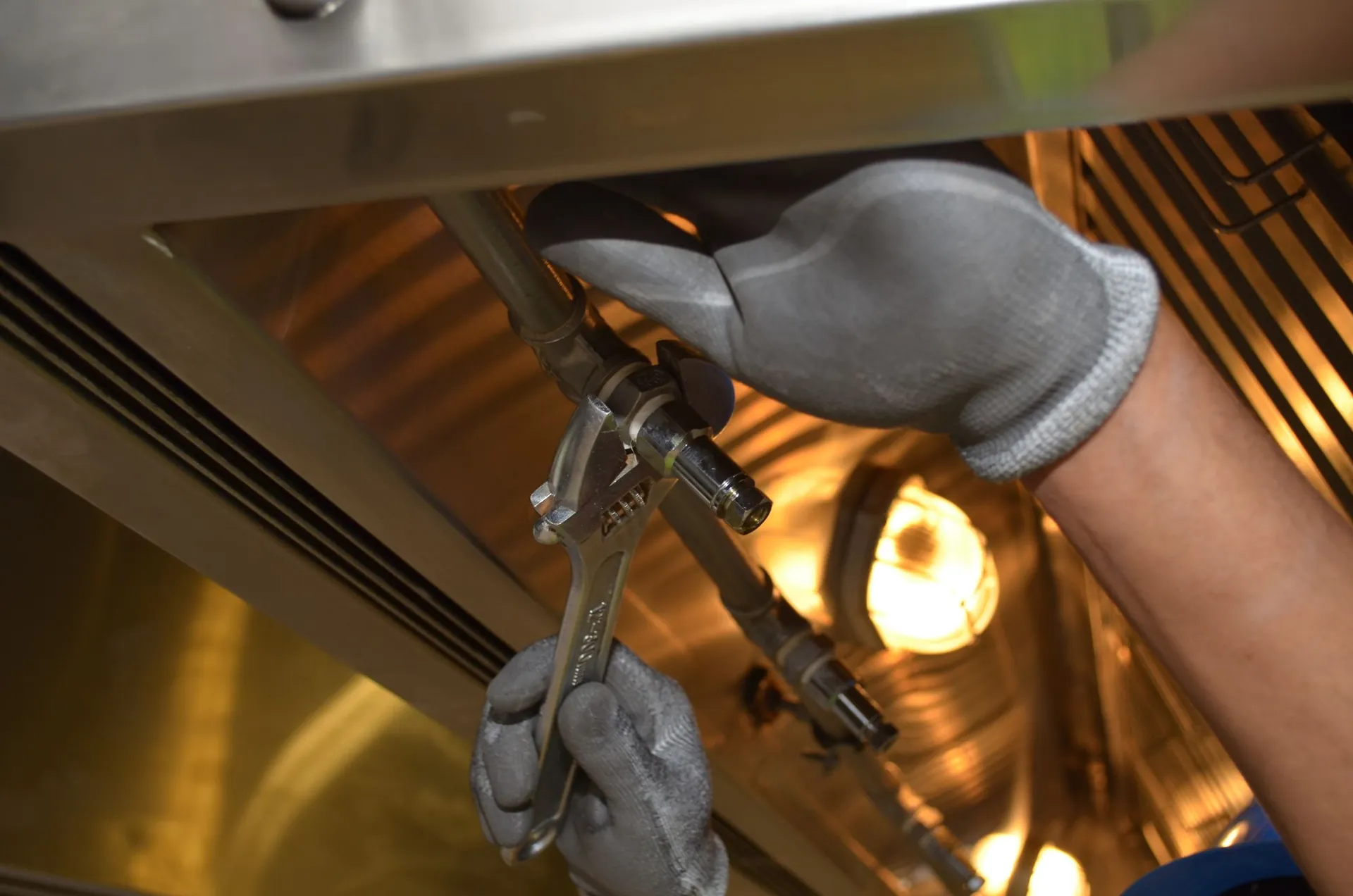 Engineer tightening a fitting on heating pipework with a spanner