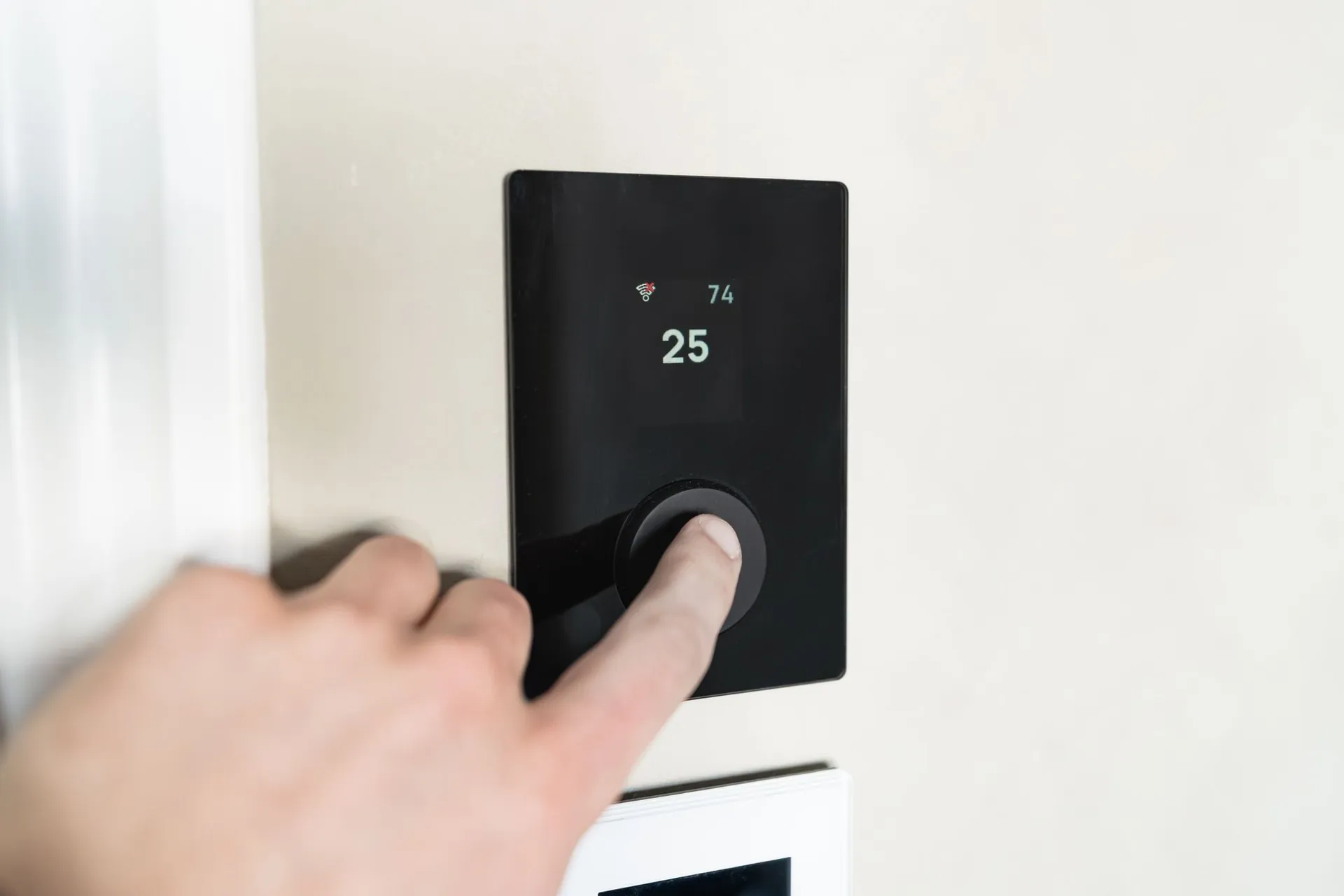 Wall-mounted smart heating thermostat showing the room temperature
